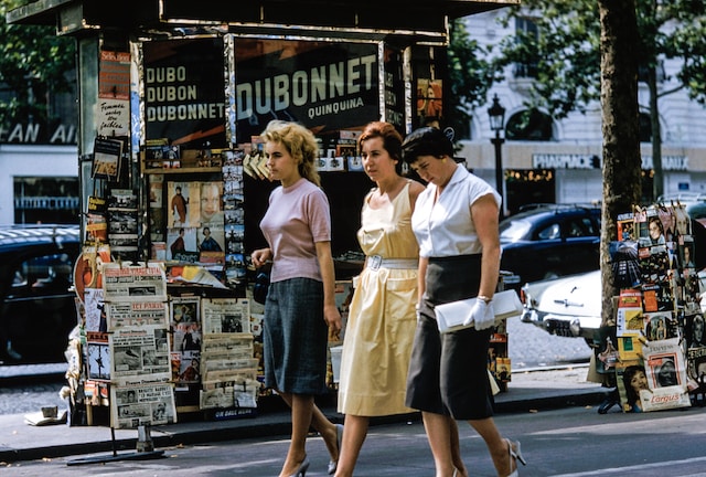 Three women in retro clothing walking on the street.