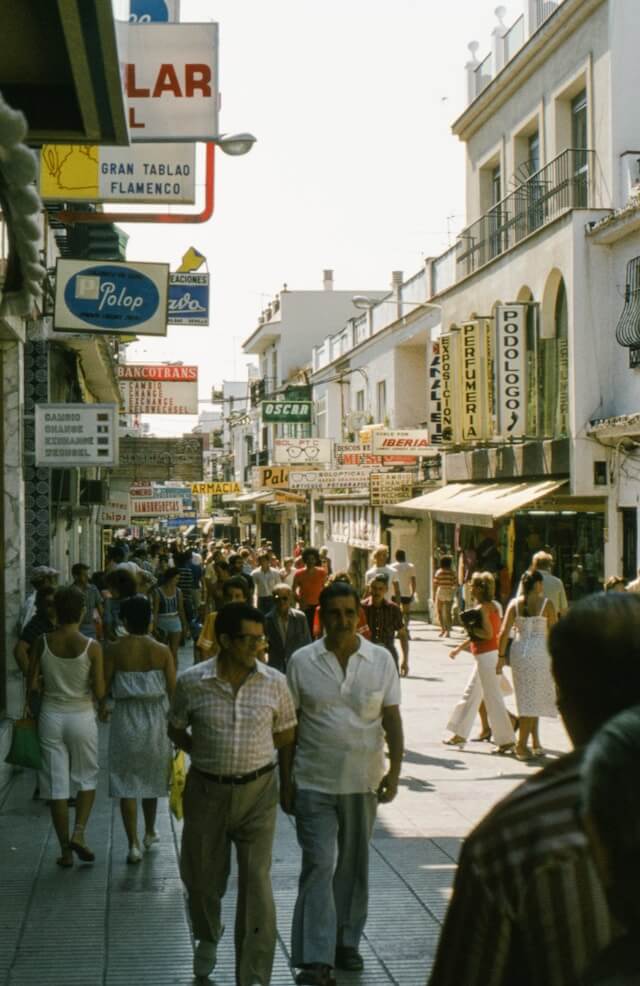 A bustling street with people walking about circa 1980s.