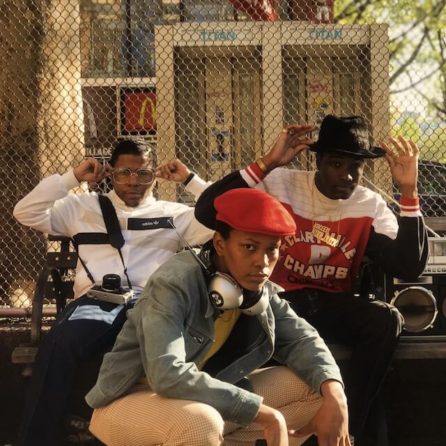 Three young men wearing 80's inspired streetwear.
