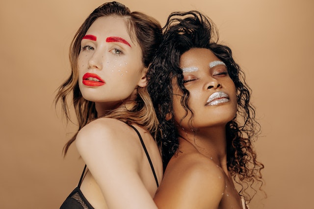 Two women wearing glittery make-up.