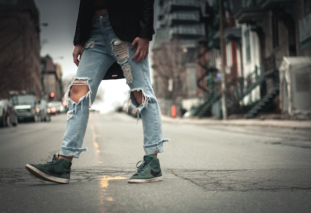 Person crossing the street wearign ripped jeans