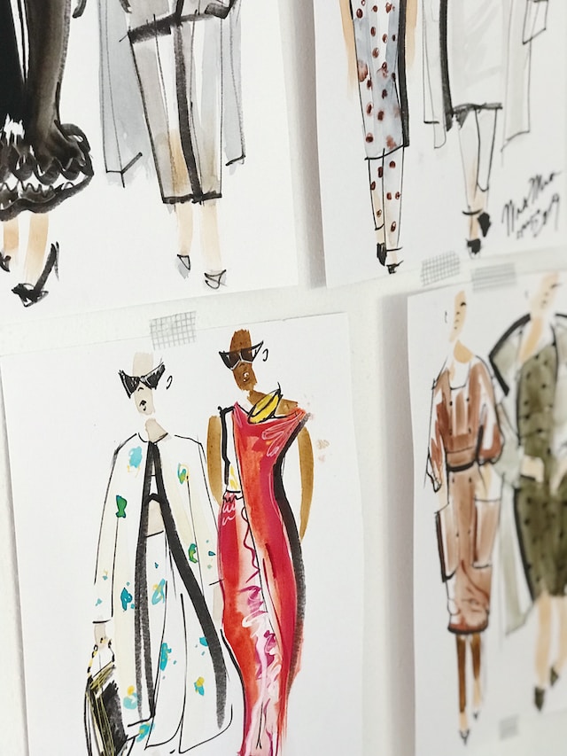 Pictures of fashion sketches taped on a wall 