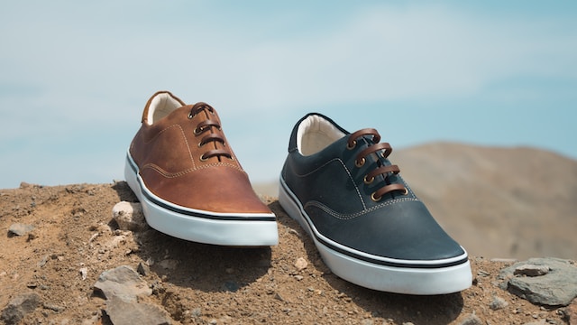 Brown and dark gray sneakers on a sandy ground